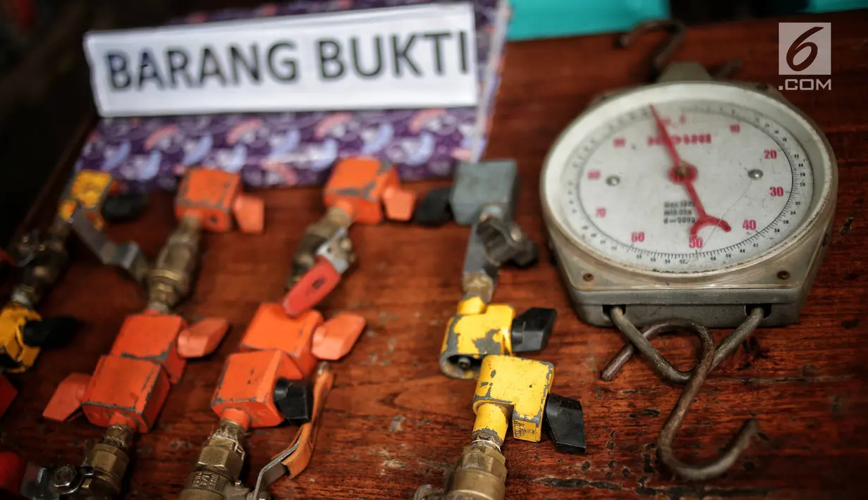 Barang bukti tabung gas oplosan di Cipayung, Jakarta, Selasa (22/1). Polda Metro Jaya menyita 1.200 tabung LPG ukuran 3 Kg, 242 ukuran 12 Kg, 14 selang pipa besi regulator pemindah isi gas dan 1 kantong segel tabung gas. (Liputan6.com/Faizal Fanani)