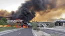 Asap membumbung saat kereta barang tergelincir dan terbakar di jembatan Danau Kota Tempe, Arizona, Amerika Serikat, Rabu (29/7/2020). Tidak ada korban luka dalam kecelakaan yang menurut seorang saksi digambarkan sebagai 'pemandangan neraka' tersebut. (Daniel Coronado via AP)