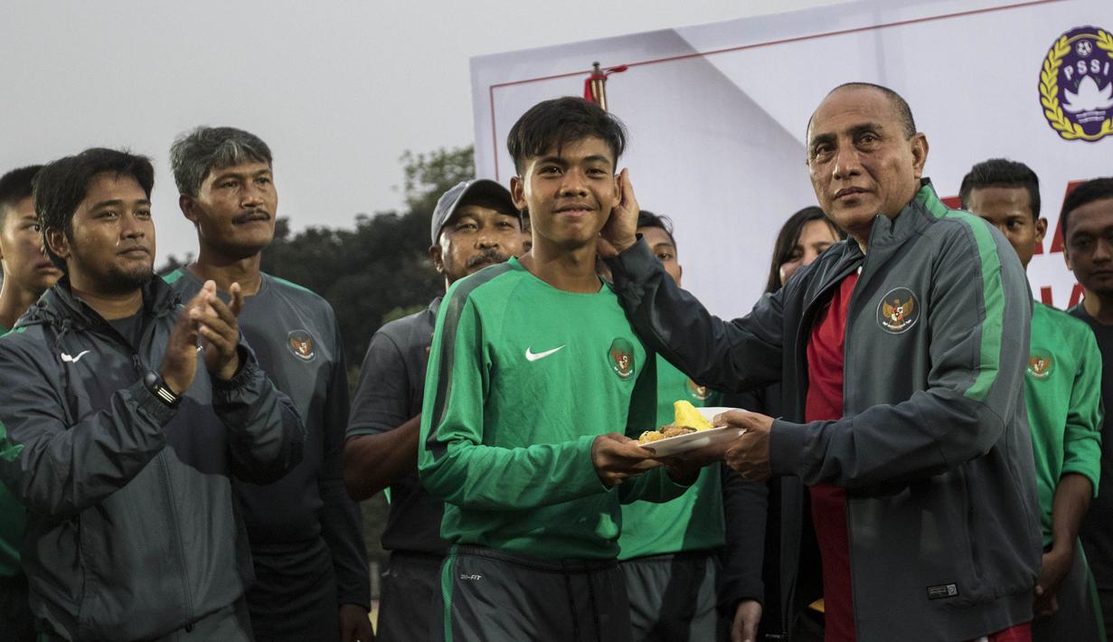 Ketum PSSI, Edy Rahmayadi, memberi potongan tumpeng kepada kapten Timnas Indonesia U-16, David Maulana, di Stadion Atang Sutresna, Jakarta Timur, Rabu (12/9/2017). Timnas U-16 akan mengikuti kualifikasi Piala AFC U-16. (Bola.com/Vitalis Yogi Trisna)