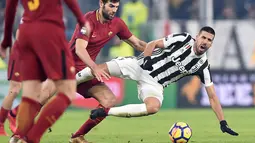Pemain Juventus, Sami Khedira terjatuh saat berebut bola dengan pemain Roma, Federico Fazio saat pertandingan Liga Italia di Turin, Italia (23/12). Pada pertandingan ini Juventus menang 1-0 atas Roma. (Alessandro Di Marco / ANSA via AP)