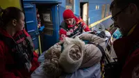 Relawan Palang Merah membawa seorang wanita dengan tandu ke kereta medis Medecins Sans Frontieres (MSF) atau Doctors Without Border saat mengevakuasi pasien dari dekat garis depan pertempuran ke daerah yang lebih aman di stasiun kereta di Pokrovsk, Ukraina, 7 Maret 2023. MSF merupakan kereta medis khusus yang dapat membawa pasien dari bagian timur Ukraina ke rumah sakit di bagian barat. (AP Photo/Evgeniy Maloletka)