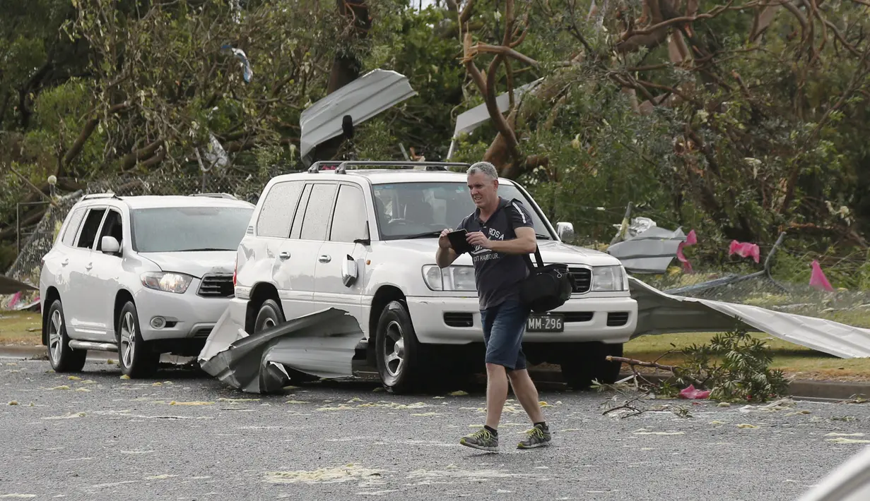 Seorang pria mengambil gambar kerusakan yang diakibatkan badai tornado yang langka di Kurnell pinggir Sydney, Rabu (16/12). Badai dengan hujan es disertai angin berkekuatan sampai 200 km per jam melanda kawasan tersebut. (REUTERS/Jason Reed)