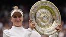 Selebrasi petenis tunggal putri Republik Ceska, Marketa Vondrousova dengan trofi juara setelah mengalahkan petenis Tunisia, Ons Jabeur pada laga final turnamen tenis Wimbledon 2023 di All England Lawn and Tennis Club, London, Sabtu (16/7/2023) malam WIB. (AP Photo/Alberto Pezzali)