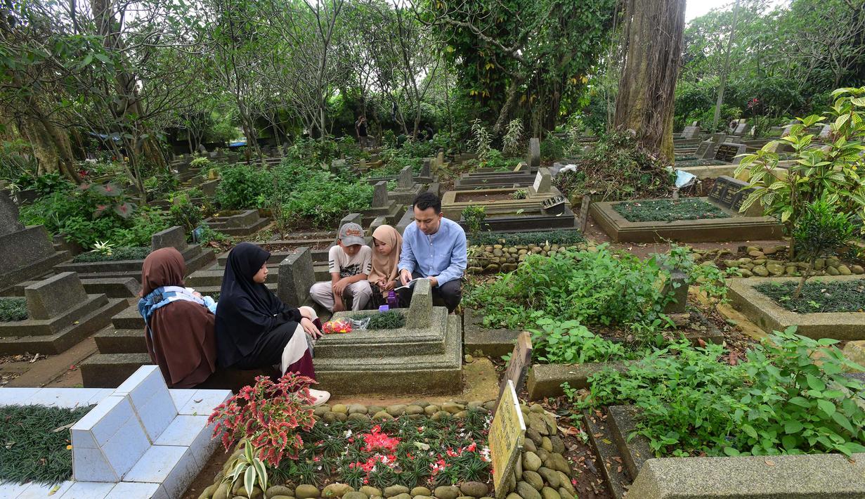 Ziarah makam merupakan tradisi dilakukan sebagian besar masyarakat Indonesia untuk mendoakan keluarga yang telah wafat dan membersihkan pusara. Tampak dalam foto, warga saat berziarah di makam keluarganya di Tempat Pemakaman Umum (TPU) Dreded, Bogor, Jawa Barat, Minggu (15/2/2026). (merdeka.com/Arie Basuki)