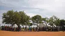 Pengungsi Sudan Selatan menunggu untuk didaftarkan saat tiba di Pos Perbatasan Ngomoromo, Uganda, Senin (10/4). Menurut UNHCR lebih dari 6.000 orang telah melarikan diri ke distrik Uganda utara Lamwo. (AFP PHOTO / ISAAC KASAMANI)