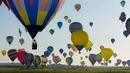 Ratusan balon udara terbang di pangkalan udara Chambley-Bussieres, Hagéville, Prancis, Senin (29/7/2019). Acara itu disebut sebagai salah satu festival balon udara terbesar di dunia. (Jean-Christophe VERHAEGEN/AFP)