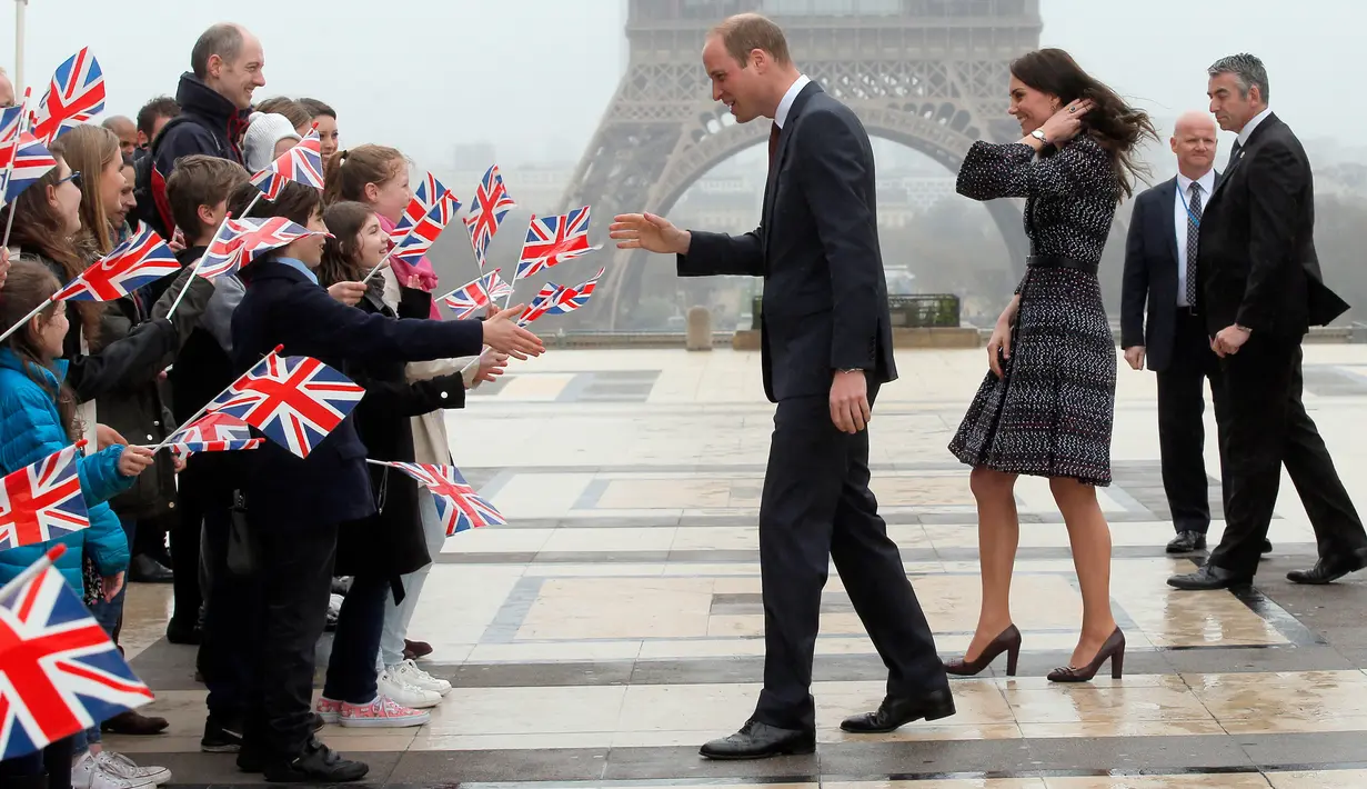 Anak-anak dari proyek Somme milik The British Council menyambut kedatangan Pangeran William dan Kate Middleton di Trocadero square, Paris, 18 Maret 2017. Dalam lawatannya ke Paris, Kate dan William tampak masih bersama. (AP Photo/Michel Euler, Pool)