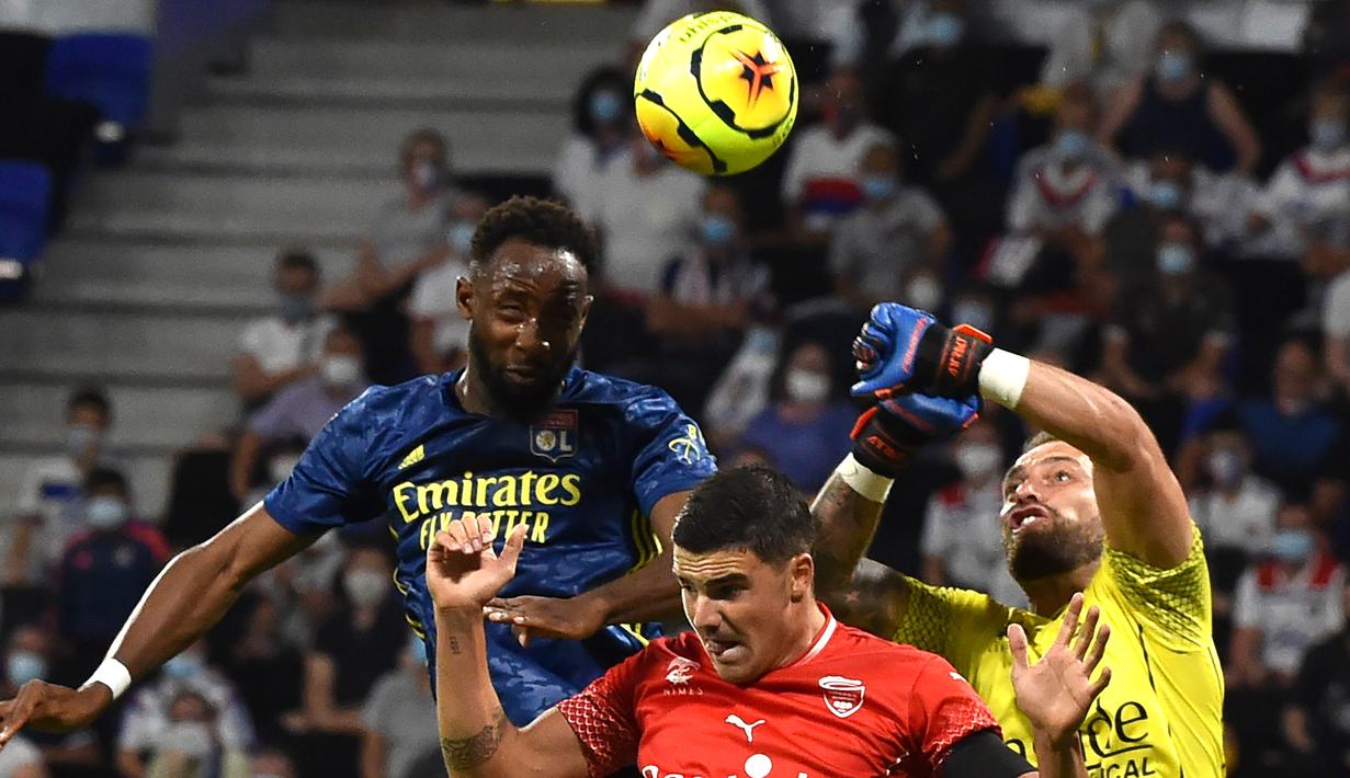 Penyerang Lyon, Moussa Dembele, berusaha menyundul bola saat menghadapi Nimes pada laga lanjutan Liga Prancis di Stadion Groupama, Sabtu (19/9/2020) dini hari WIB. Lyon bermain imbang 0-0 atas Nimes. (AFP/Jean-Philippe Ksiazek)