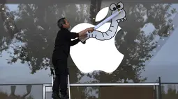 Aktivis Asosiasi Perpajakan Transaksi Keuangan dan Aksi Warga Negara (ATTAC) memasang poster di jendela toko Apple saat berunjuk rasa di luar toko Apple saat peluncuran iPhone X di Aix-en- Provence, Prancis (3/11). (AFP Photo/Anne-Christine Poujoulat)