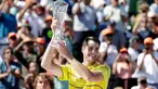 Petenis AS, John Isner memegang trofi seusai meraih gelar juara Miami Terbuka 2018 di Key Biscayne, Minggu (1/4). Pada laga final yang menegangkan tersebut, Isner sukses menaklukkan petenis Jerman Alexander Zverev 6-7, 6-4, 6-4. (AP/Lynne Sladky)