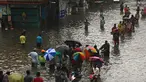 Orang-orang mengarungi jalan yang banjir setelah hujan lebat di Chennai, India (8/11/2021). Chennai dilanda Curah Hujan Terberat Sejak 2015,  Pihak berwenang Keluarkan Peringatan Banjir. (AFP/Arun Sankar)