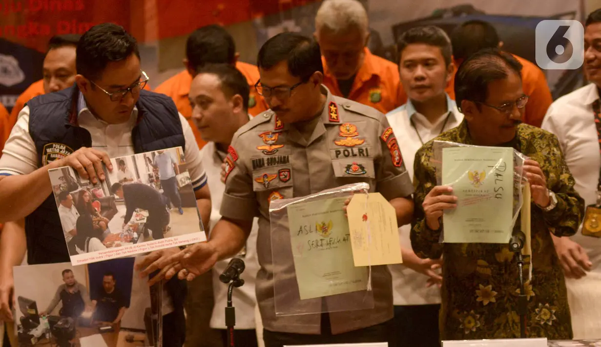 Kapolda Metro Jaya Rijen Pol Nana Sujana (tengah) bersama Menteri ATR/BPN Sofyan A. Djalil (kanan) menunjukkan barang bukti sertifikat tanah palsu saat rilis kasus sindikat mafia tanah di Jakarta, Rabu (12/2/2020). (merdeka.com/Imam Buhori)