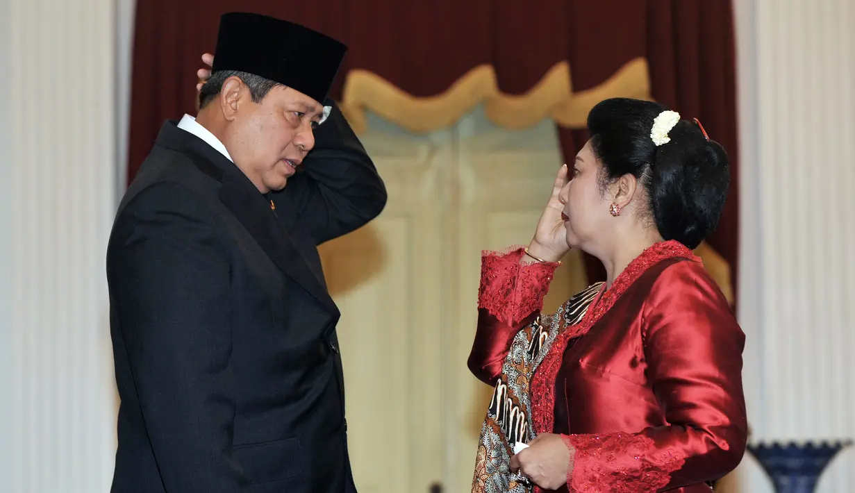 Presiden ke-6 RI Susilo Bambang Yudhoyono (SBY) membenarkan kopiahnya dengan arahan sang istri, Ani Yudhoyono saat pelantikannya sebagai presiden kedua kalinya di Istana Merdeka, Jakarta, 20 Oktober 2009. (AFP PHOTO/ADEK BERRY)