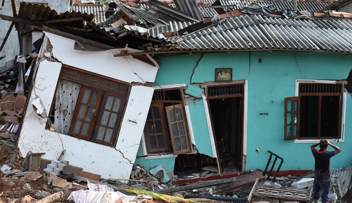 Warga Sri Lanka mengamati rumahnya yang rusak tertimbun gundukan sampah yang longsor di Meetotamulla, dekat ibukota Kolombo, Minggu (16/4). Sedikitnya 23 orang tewas akibat tanah longsor di tempat pembuangan sampah tersebut. (ISHARA S. KODIKARA/AFP)