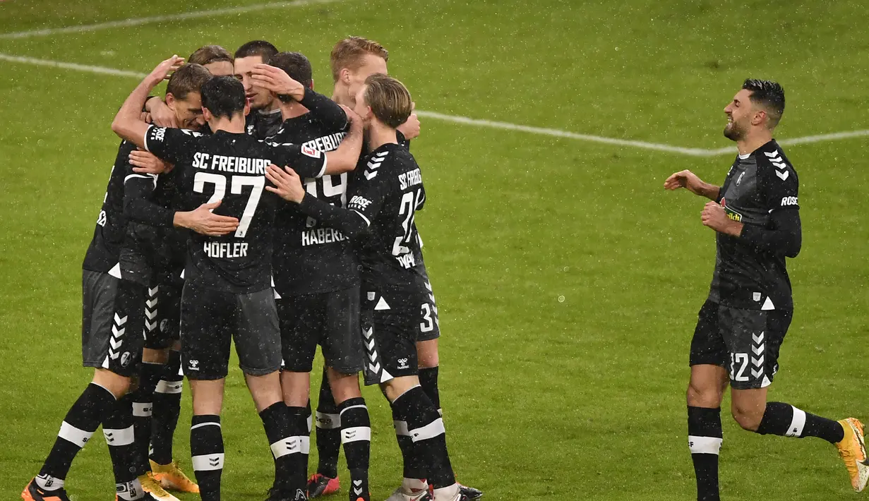 Para pemain Freiburg merayakan gol penyeimbang 1-1 yang dibuat striker Nils Petersen ke gawang Bayern Munich dalam laga lanjutan Liga Jerman 2020/21 pekan ke-16 di Allianz Arena, Minggu (17/1/2021). Freiburg kalah 1-2 dari Bayern Munich. (AFP/Lukas Barth-Tuttas/Pool)
