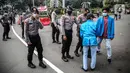 Polisi memeriksa barang bawaan mahasiswa yang akan berunjuk rasa di Patung Kuda, Jakarta, Selasa (20/10/2020). Pemeriksaan tersebut dilakukan untuk memastikan unjuk rasa berjalan aman dan damai. (Liputan6.com/Faizal Fanani)