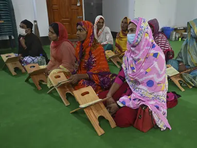 Anggota komunitas transgender belajar membaca Alquran di dalam Madrasah Dawatul Islam Tritio Linger untuk jenis kelamin ketiga, di Dhaka, Bangladesh, Selasa (17/11/2020). Ibu kota Bangladesh, Dhaka membuka madrasah pertama untuk transgender muslim pada 6 November 2020 lalu. (Munir Uz zaman/AFP)