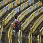 Pendukung Peru melewati kursi kosong Stadion Maracana jelang laga melawan Bolivia pada Copa America 2019, Senin (18/6/2018). (AFP/Mauro Pimentel)