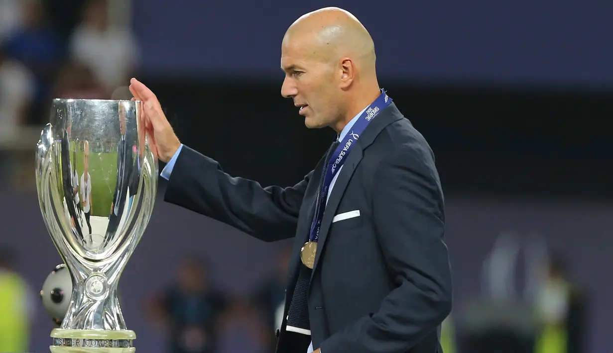 Pelatih Real Madrid Zinedine Zidane menyentuh trofi saat pertandingan sepak bola final Piala Super Eropa antara Real Madrid dan MU di Philip II Arena di Skopje, (8/8). Real Madrid mengalahkan Manchester United 2-1. (AP Photo/Boris Grdanoski)