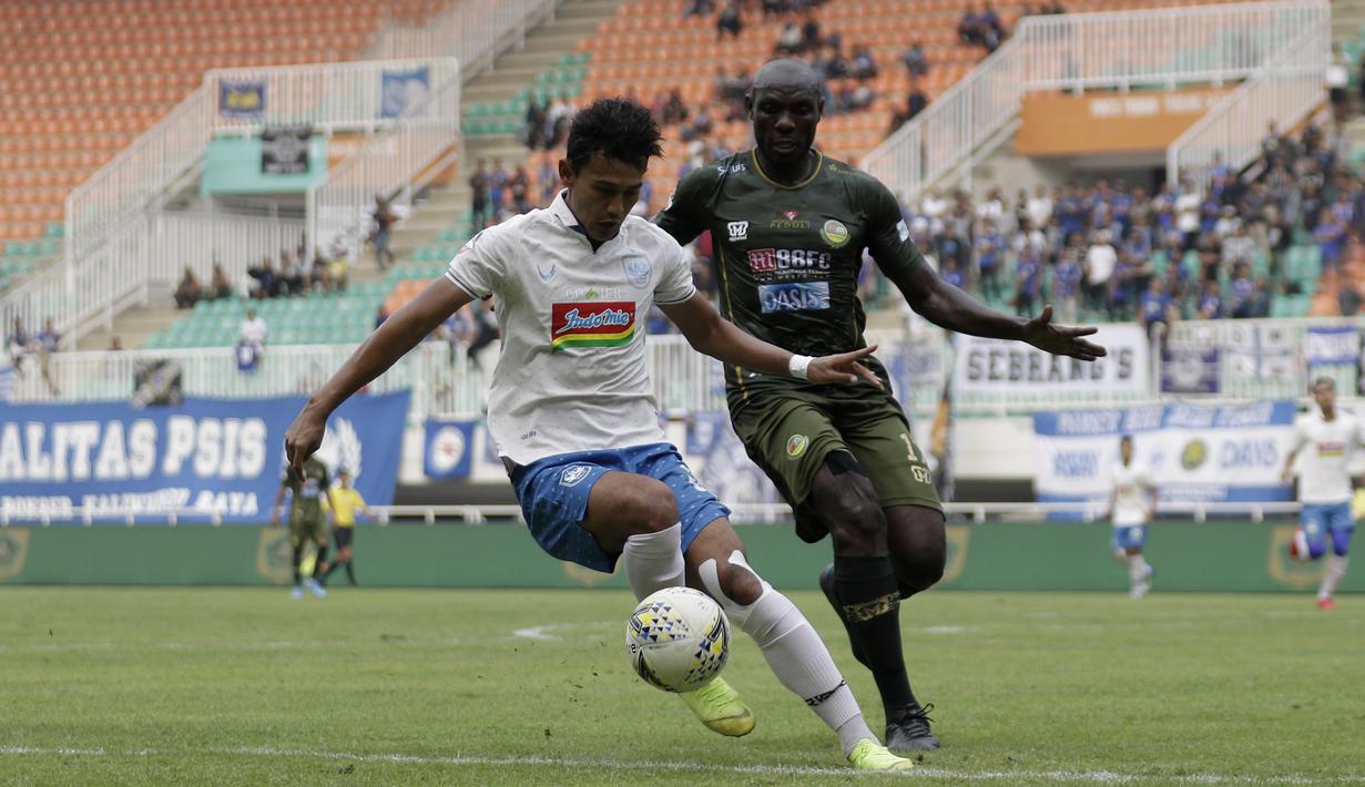 Striker PSIS Semarang, Hari Nur, berebut bola dengan bek Tira Persikabo, Mountala Zoubairou, pada laga Shopee Liga 1 di Stadion Pakansari, Bogor, Jumat (22/11). PSIS menang 2-1 atas Tira Persikabo. (Bola.com/Yoppy Renato)