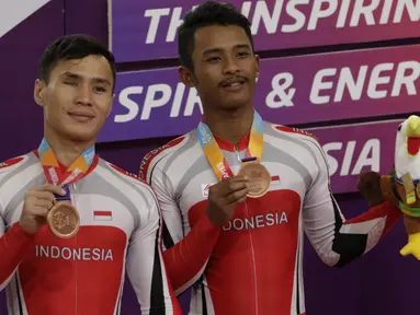 Pebalap sepeda Indonesia, Herman Halawa dan Pradana Diwan, saat menerima medali pada Asian Para Games di Velodrome, Jakarta, Kamis (11/10/2018). Pasangan Indonesia ini meraih perunggu di nomor trek Individual Pursuit B putra. (Bola.com/M Iqbal Ichsan)