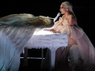 Penyanyi Lady Gaga tampil dengan piano putih berbalut sepasang sayap raksasa di panggung Grammy Awards 2018, New York,  Minggu (28/1). Bergaun baby pink yang memukau, Gaga membawakan lagu Joanne dan Million Reasons. (KEVIN WINTER/GETTY IMAGES/AFP)