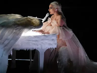 Penyanyi Lady Gaga tampil dengan piano putih berbalut sepasang sayap raksasa di panggung Grammy Awards 2018, New York,  Minggu (28/1). Bergaun baby pink yang memukau, Gaga membawakan lagu Joanne dan Million Reasons. (KEVIN WINTER/GETTY IMAGES/AFP)