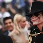 Pria berpenampilan Michael Jackson berpose di karpet merah pemutaran film Solo: A Star Wars Story pada Festival Film Cannes, Selasa (15/5). Kehadiran pria mirip mendiang raja musik pop dunia tersebut mengundang perhatian. (AFP/Anne-Christine POUJOULAT)