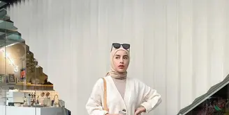 Cocok untuk musim dingin, padukan knit cardigan dengan kulot putih dan hijab warna nude. Tambahkan pula aksesori berupa kacamata  untuk look yang chic. (Instagram/emyaghnia).