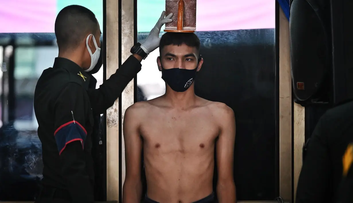 Seorang pria muda menjalani pemeriksaan fisik selama wajib militer tahunan di Bangkok (23/7/2020). (AFP Photo/Lillian Suwanrumpha)