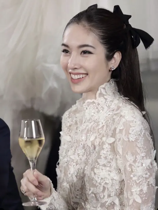 Hadirkan kesan yang begitu fresh, Nong Poy hadirkan makeup yang flawless. Foundation dengan sentuhan dewy look sempurnakan kulitnya yang begitu sempurna. Gaya rambut dengan aksen pita juga ciptakan gaya yang begitu anggun.  [Foto: Instagram/ @poydtreechada]