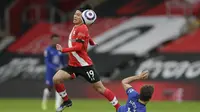 Takumi Minamino terbang menghindari tekel pemain Chelsea. Pada laga ini, ia mencetak satu gol dan Southampton bermain imbang 1-1, Sabtu (20/02/2021) malam WIB. (KIRSTY WIGGLESWORTH / POOL / AFP)