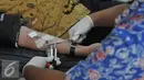 Petugas mengambil darah seorang karyawan saat aksi donor darah di ruang rapat BPPK Kemenlu, Jakarta, Jumat (24/7/15). Aksi donor darah tersebut menyambut hari kemerdekaan Indonesia pada tanggal 17 agustus nanti. (Liputan6.com/Herman Zakharia)