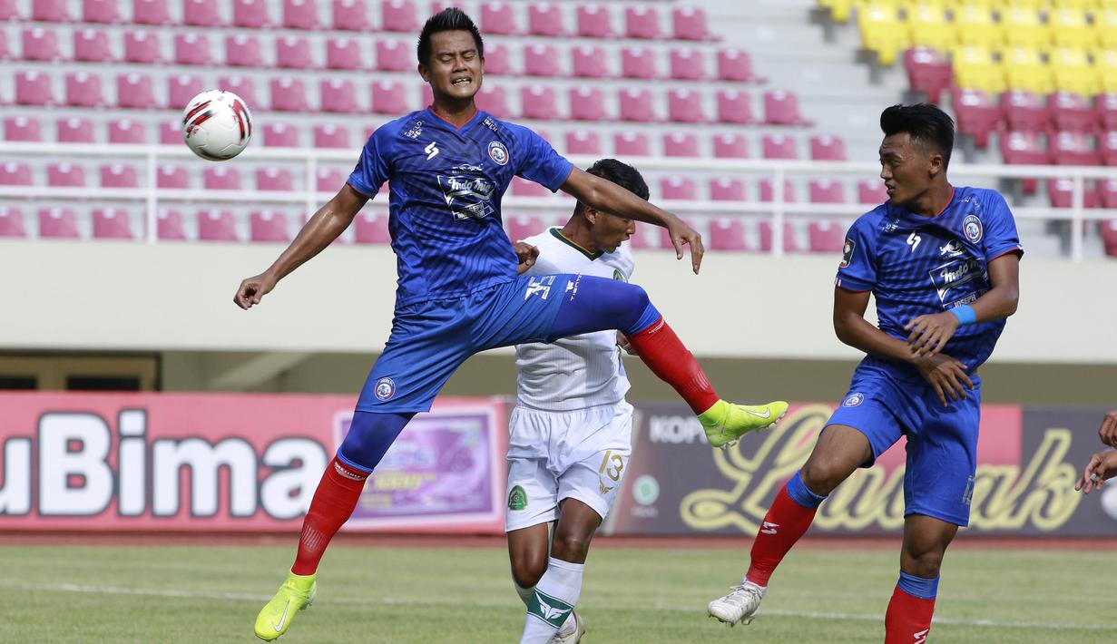 Bek Arema FC, M. Roby (kiri) berduel udara dengan bek Persikabo 1973, Didik Wahyu Wijayance (belakang) dalam laga pembuka Piala Menpora 2021 di Stadion Manahan, Solo, Minggu (21/3/2021). Arema FC sementara tertinggal 0-1 dari Persikabo 1973. (Bola.com/M Iqbal Ichsan)