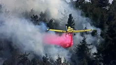 Sebuah pesawat pemadam kebakaran bekerja memadamkan kebakaran hutan yang berkobar di dekat kibbutz Maale Hahamisha di daerah desa Arab-Israel Abu Ghosh dekat Yerusalem, Israel, Rabu (9/6/2021). Kebakaran hebat di pinggiran Yerusalem melumpuhkan lalu lintas. (Menahem KAHANA/AFP)