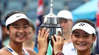 Alexandra Eala dari Filipina (kiri) dan Priska Madelyn Nugroho dari Indonesia berpose dengan piala usai mengalahkan Ziva Falkner (Slovenia)/Matilda Mutavdzic (Inggris) pada final Australia Terbuka Junior 2020 di Melbourne, Jumat (31/1/2020). Priska/Alexandra menang 6-1, 6-2. (AP/Dita Alangkara)
