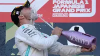 Pembalap Mercedes, Valtteri Bottas menuangkan sampanye untuk dirinya sendiri di atas podium setelah menjuarai balapan Formula 1 (F1) GP Jepang di Sirkuit Suzuka, Minggu (13/10/2019). Bottas menjadi pembalap pertama yang menyentuh garis finis usai melakoni lomba 53 putaran. (AP/Toru Takahashi)