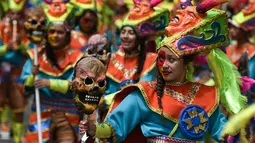 Peserta mengenakan kostum dan riasan menari saat parade Canto a la Tierra di Pasto, Kolombia (3/1). Lebih dari 10.000 orang yang terdiri dari seniman dan pengrajin memeriahkan karnaval orang kulit hitam dan kulit putih ini. (AFP Photo/Luis Robayo)