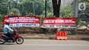Kendaraan melintasi karangan bunga yang menghiasi kawasan Patung Kuda, Jakarta, Kamis (15/10/2020). Karangan bunga tersebut merupakan apresiasi masyarakat kepada TNI-Polri yang telah menjaga keamanan saat demo. (Liputan6.com/Faizal Fanani)