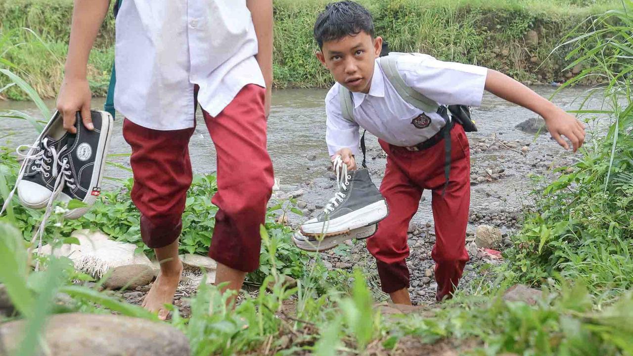 FOTO: Ketiadaan Jembatan  Penghubung Membuat Puluhan Siswa Menyeberang Sungai Menuju Sekolah di Dramaga Bogor