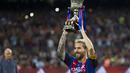 Lionel Messi mengangkat trofi  Super Cup Spanyol usai timnya menang aggregat 5-0 atas Sevilla di Stadion Camp Nou, Barcelona (18/8/2016). (EPA/Quique Garcia)
