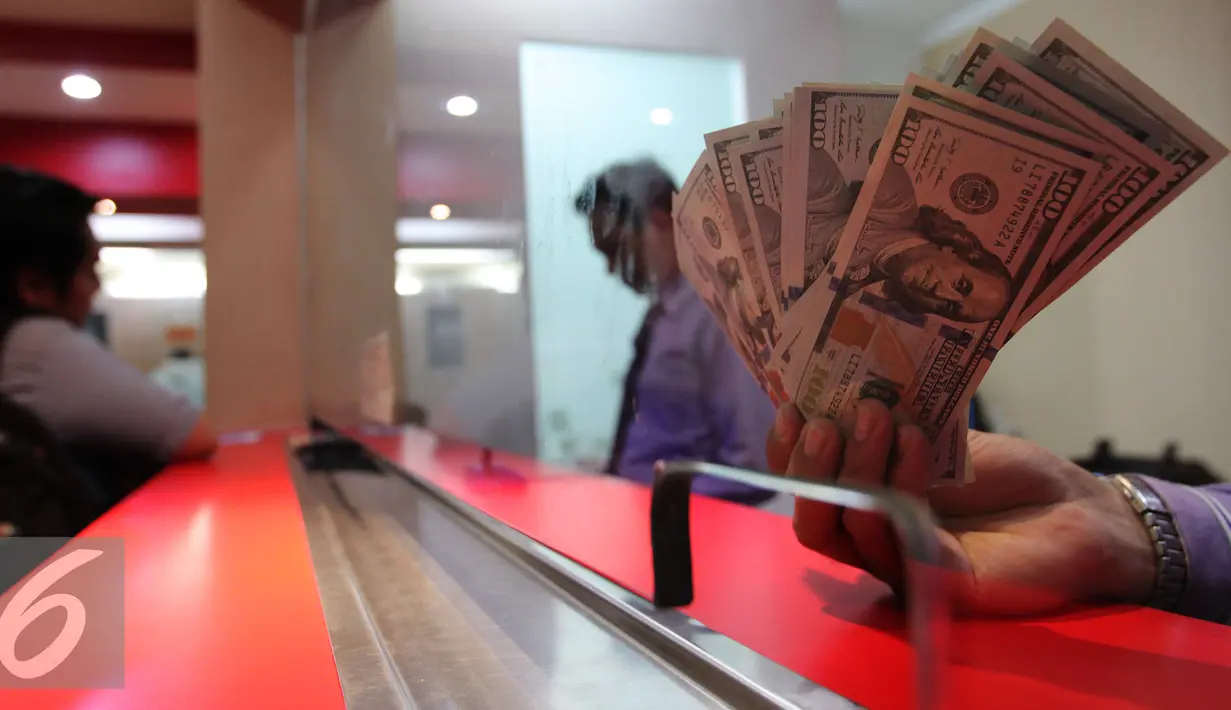 Seorang teller menunjukan mata uang dollar di konter penjualan mata uang di Jakarta, Rabu (23/9/2015). Pada perdagangan pagi hingga siang ini, rupiah terus bergerak di kisaran 14.577 per dolar AS hingga 14.658 per dolar. (Liputan6.com/Angga Yuniar)