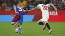Gelandang Sevilla, Juan Luis Sánchez Velasco menarik kaus pemain Barcelona, Abde Ezzalzouli pada pertandingan La Liga Spanyol di stadion Ramon Sanchez-Pizjuan, Spanyol, Rabu (22/12/2021). Hasil ini tidak mengubah posisi Barcelona pada peringkat ketujuh dengan 28 poin. (AP Photo/Angel Fernandez)