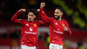 Lisandro Martinez (kiri) dan rekan setimnya, Matheus Cunha, memberikan apresiasi kepada suporter MU selepas duel melawan Newcastle United dalam lanjutan Liga Inggris 2025/2026 di Old Trafford, Sabtu (27/12/2025) dini hari WIB. (AP Photo/Dave Thompson)