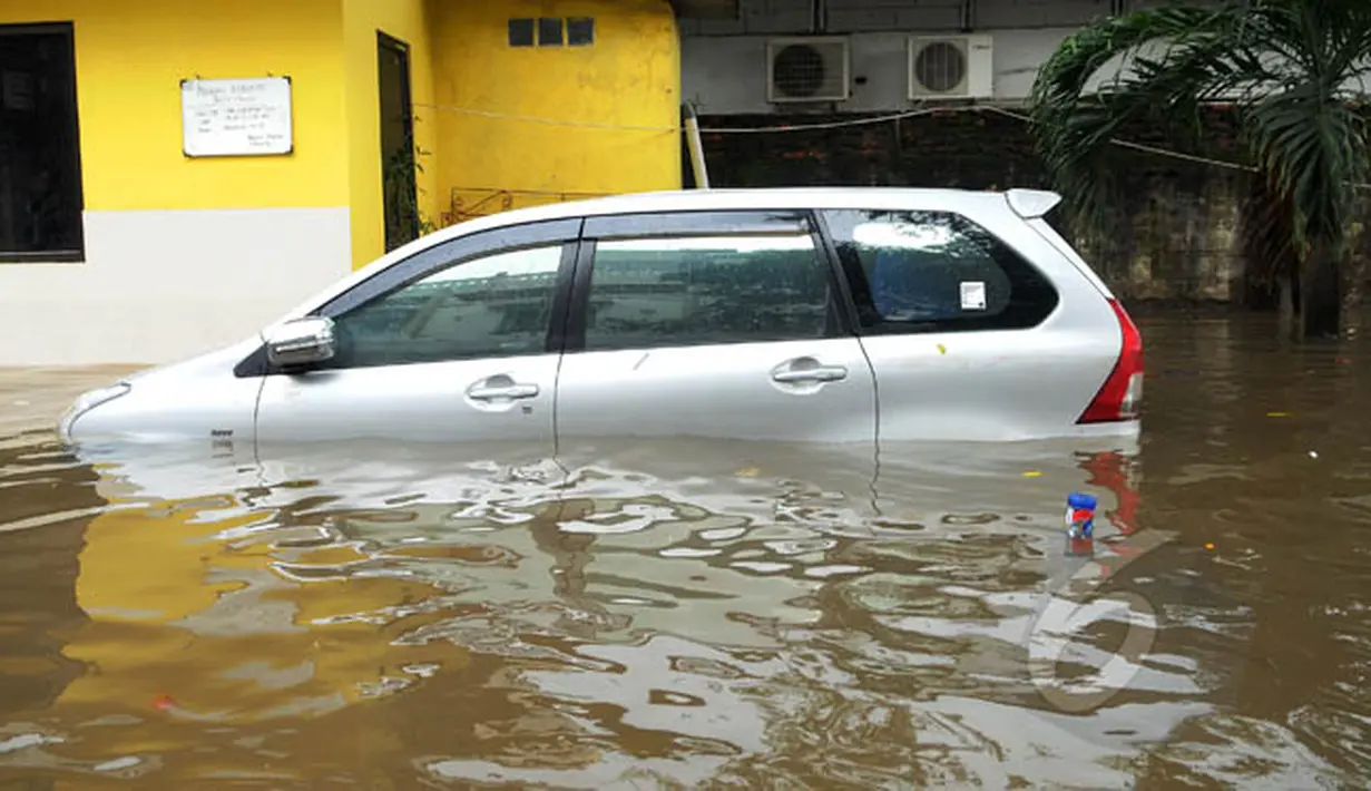 Sebuah mobil terjebak banjir di kawasan Grogol, Jakarta Barat, Rabu (11/2/2015). Hingga kini sejumlah kawasan di Jakarta masih tergenang banjir akibat dari hujan dengan intensitas tinggi yang mengguyur pada Minggu (8/2). (Liputan6.com/Faisal R Syam)
