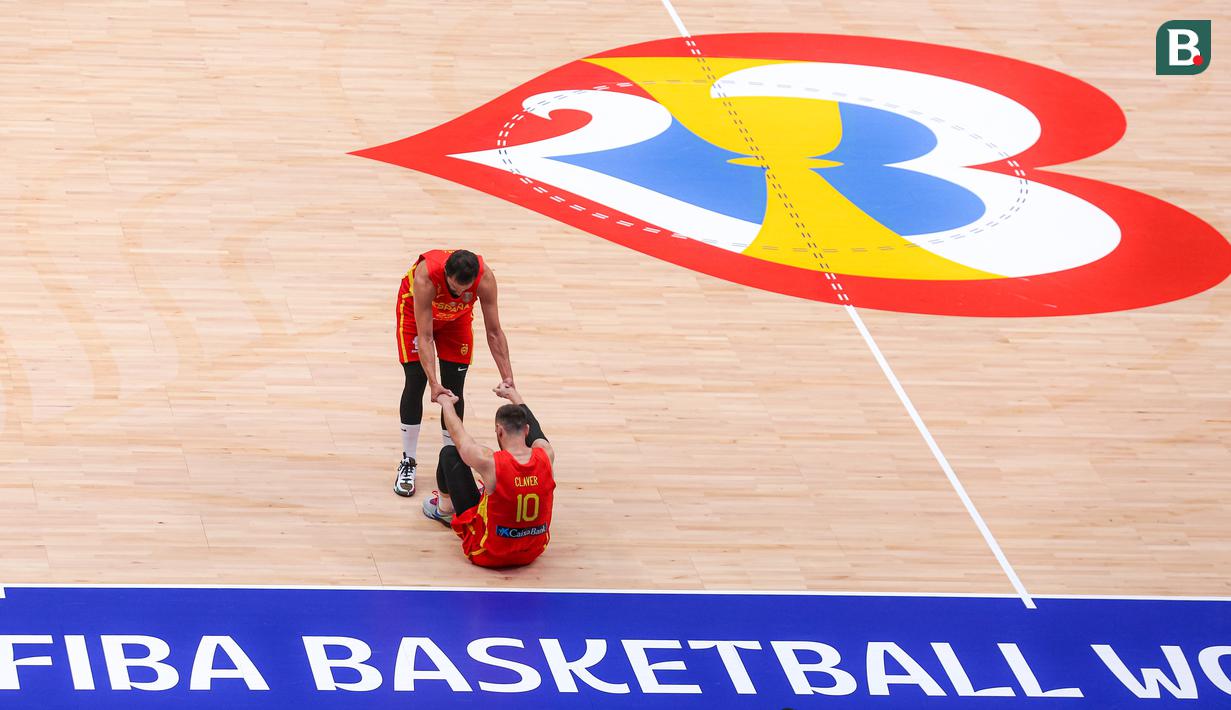 Pebasket Spanyol, Sergio Llull (kiri) membangunkan rekannya Victor Claver setelah terjatuh pada laga kedua Grup G Piala Dunia FIBA 2023 melawan Barsil di Indonesia Arena, Senayan, Jakarta, Senin (28/08/2023). Spanyol menang atas Brasil dengan skor 96-78. (Bola.com/Bagaskara Lazuardi)