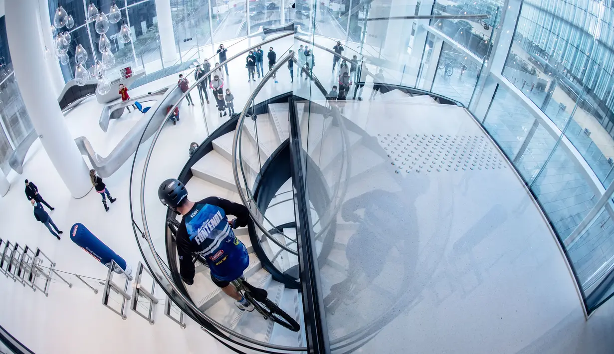 Pembalap sepeda asal Prancis, Aurelien Fontenoy, saat mendaki 768 anak tangga dari 33 lantai gedung Trinity Tower di distrik La Defense, Paris, (17/1/2021). (AFP/Martin Bureau)