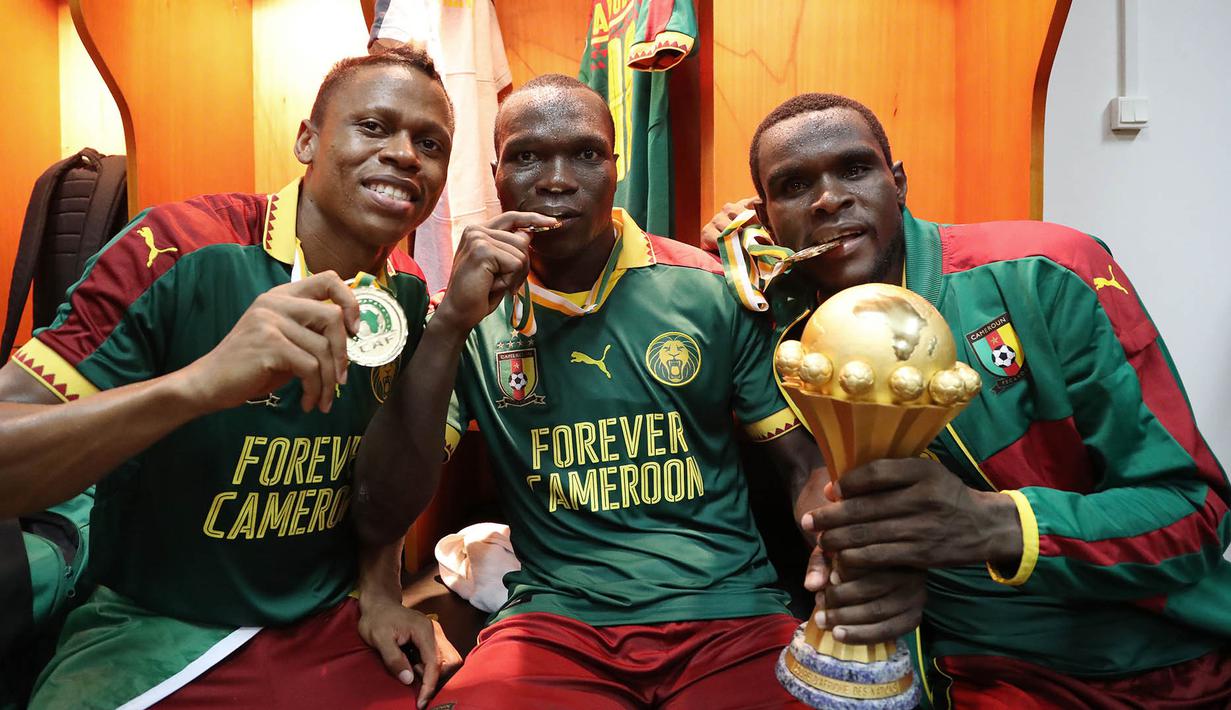 Pemain Kamerun, Clinton Njie, Vincent Aboubakar (tengah) dan Michael Ngadeu (kanan), merayakan gelar juara di ruang ganti pemain. (EPA/Gavin Barker)