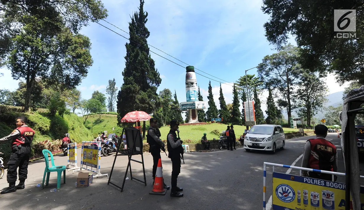 Petugas polisi berjaga di kawasan Puncak, Bogor (29/03). Akibat penutupuan itu pedagang mengeluh karena daerah mereka berjualan jadi sepi pembeli.  (Merdeka.com/Arie Basuki)