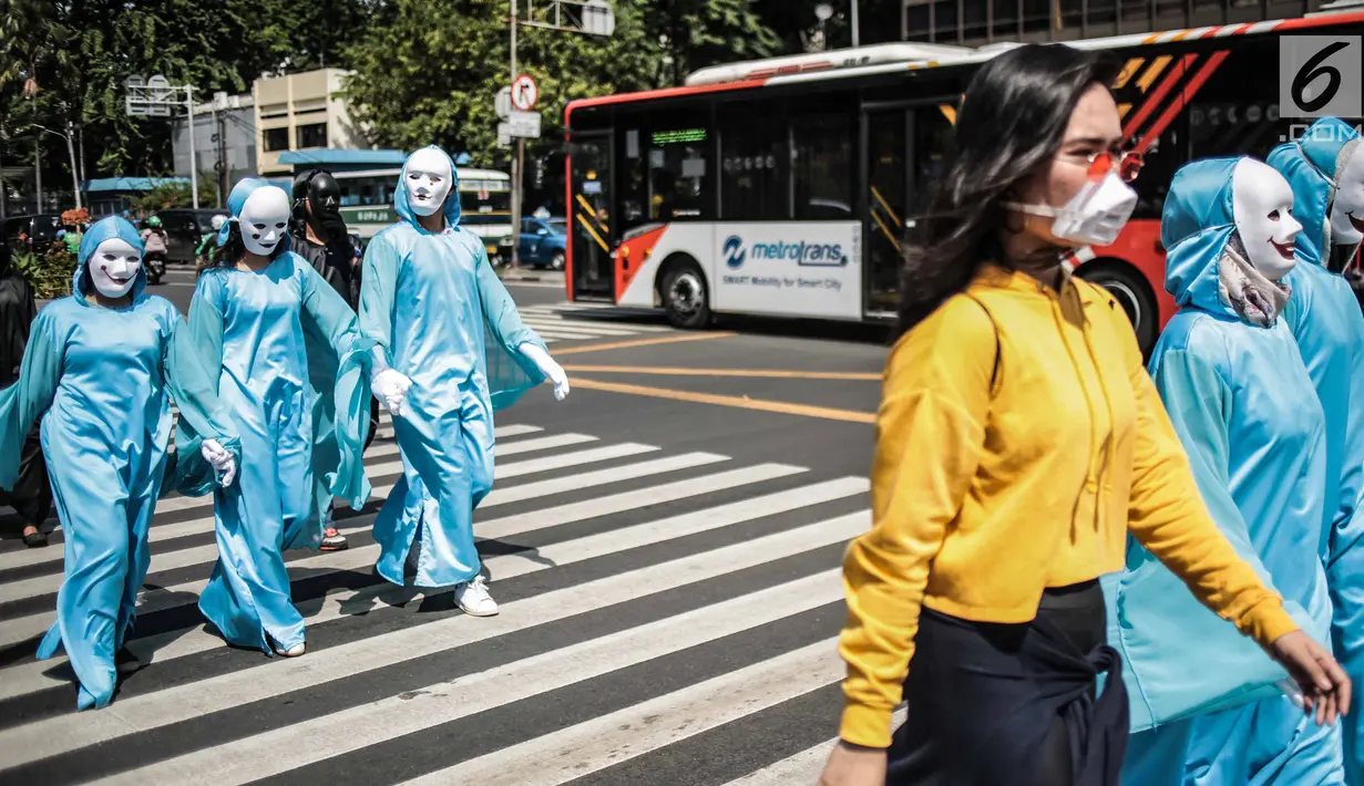 Massa menggelar aksi teatrikal di Pelican crossing di Jakarta, Kamis (20/12). Mereka mengajak pemilih milenial untuk memilih pemimpin yang berorientasi jangka panjang dan berpihak pada energi bersih, adil, dan berkelanjutan. (Liputan6.com/Faizal Fanani)